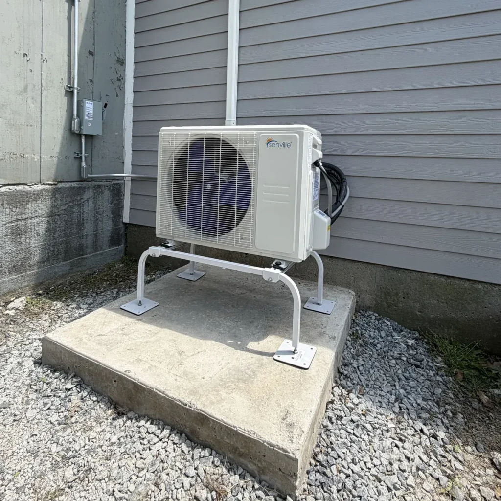 An outdoor Senville ductless condenser mounted on a ground stand with white decorative gravel in the Capital Region, NY for NYS Canal Corporation